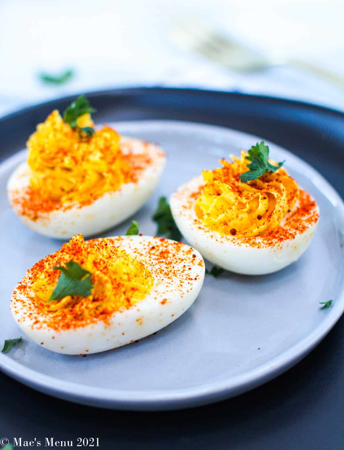 A side shot of  healthy deviled eggs  on a light blue plate