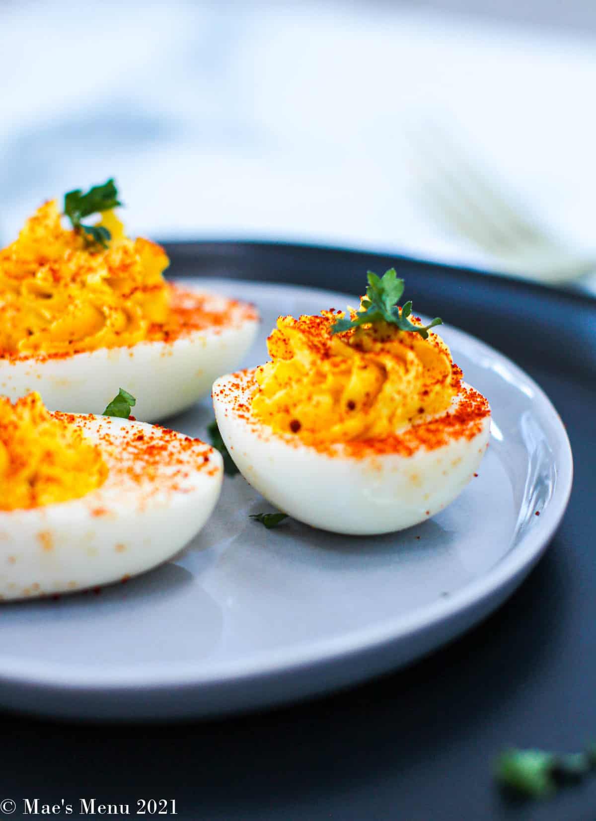 A side shot of Healthy deviled eggs on a small blue plate