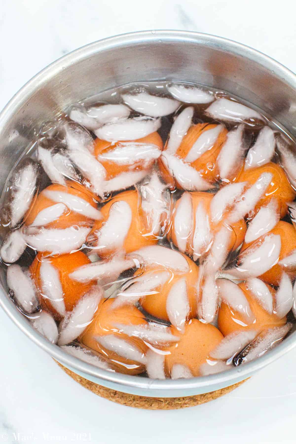 Hard-boiled eggs in a metal bowl of an ice bath
