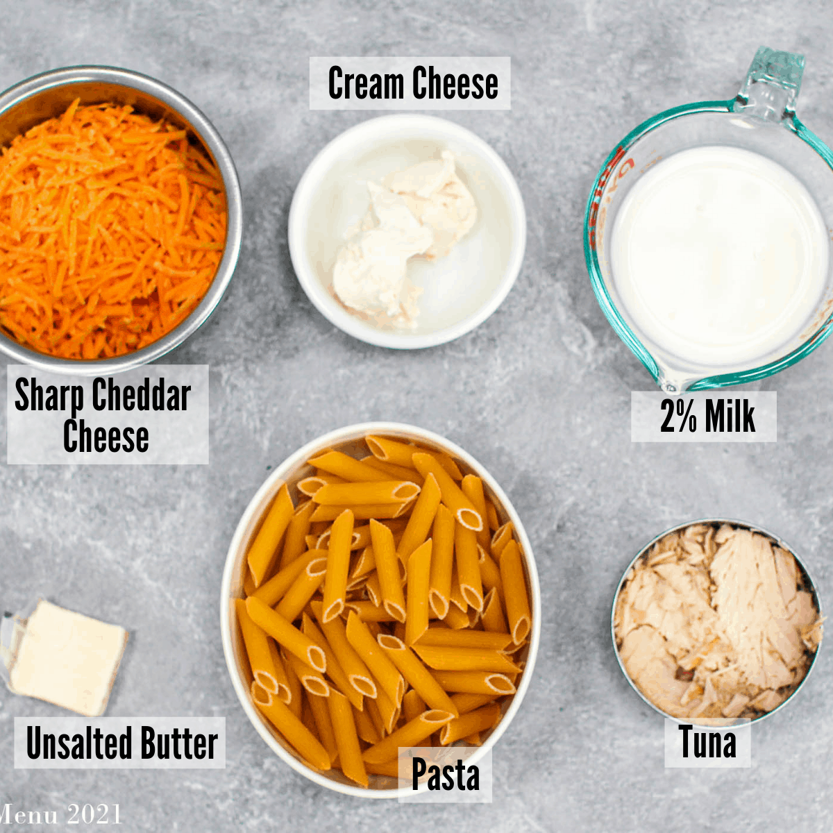 All of the ingredients for tuna mac and cheese: sharp cheddar cheese, cream cheese, 2% milk, tuna, pasta, and unsalted butter