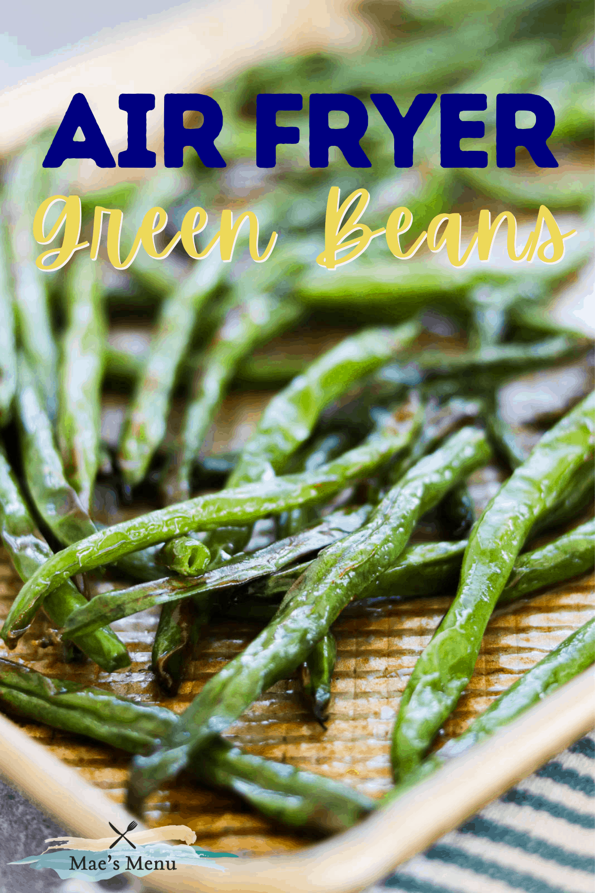 A pinterest pin for air fryer green beans with an up-close shot of the beans on a baking sheet