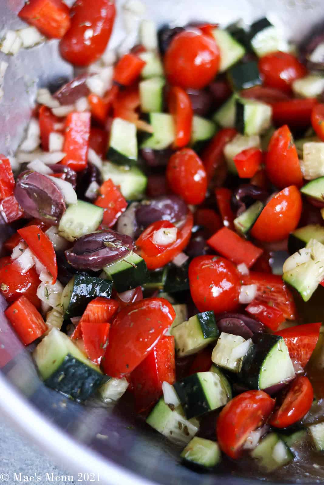 Fresh vegetables folded into the Greek salad dressing