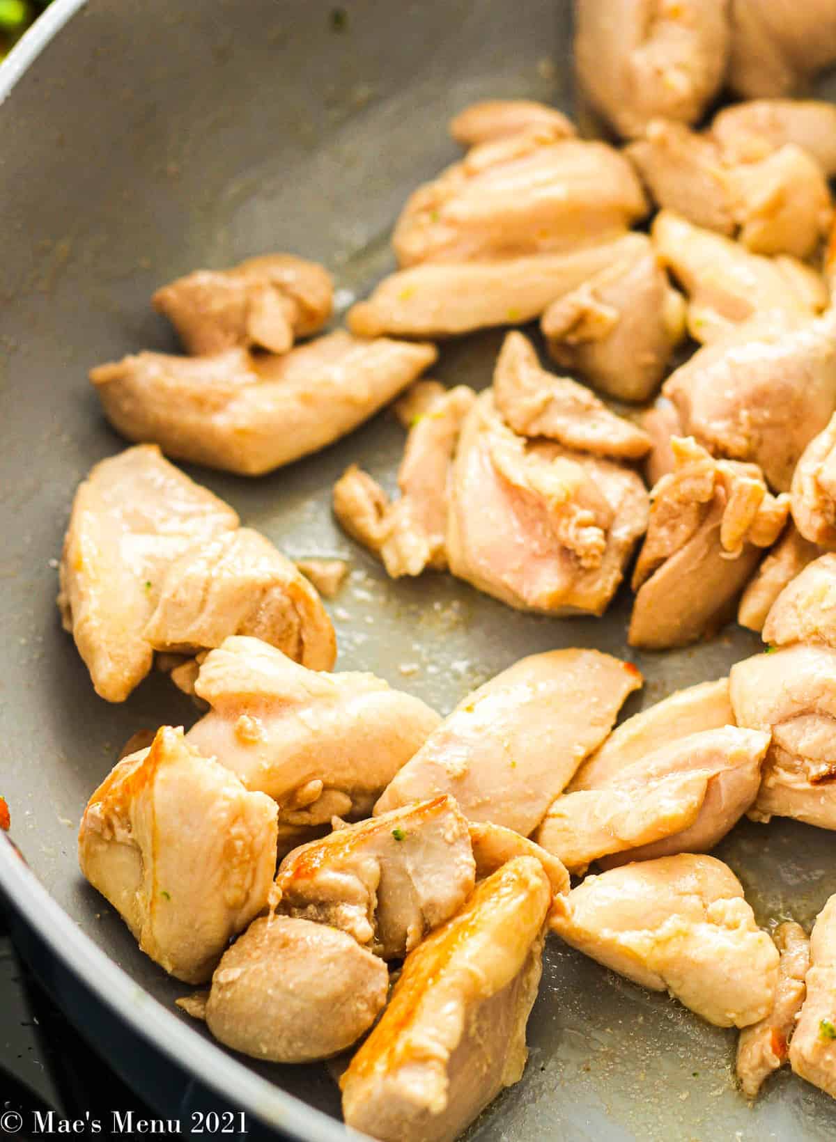 an overhead shot of chicken pieces in a skillet