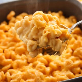 A large scoop of mac and cheese in front of a pan