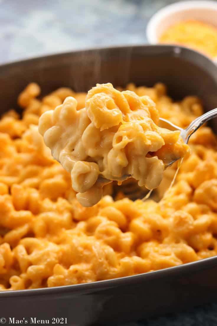 A large scoop of mac and cheese in front of a pan