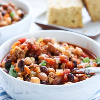 A side shot of a bowl of isntant pot turkey chili with a spoon in it