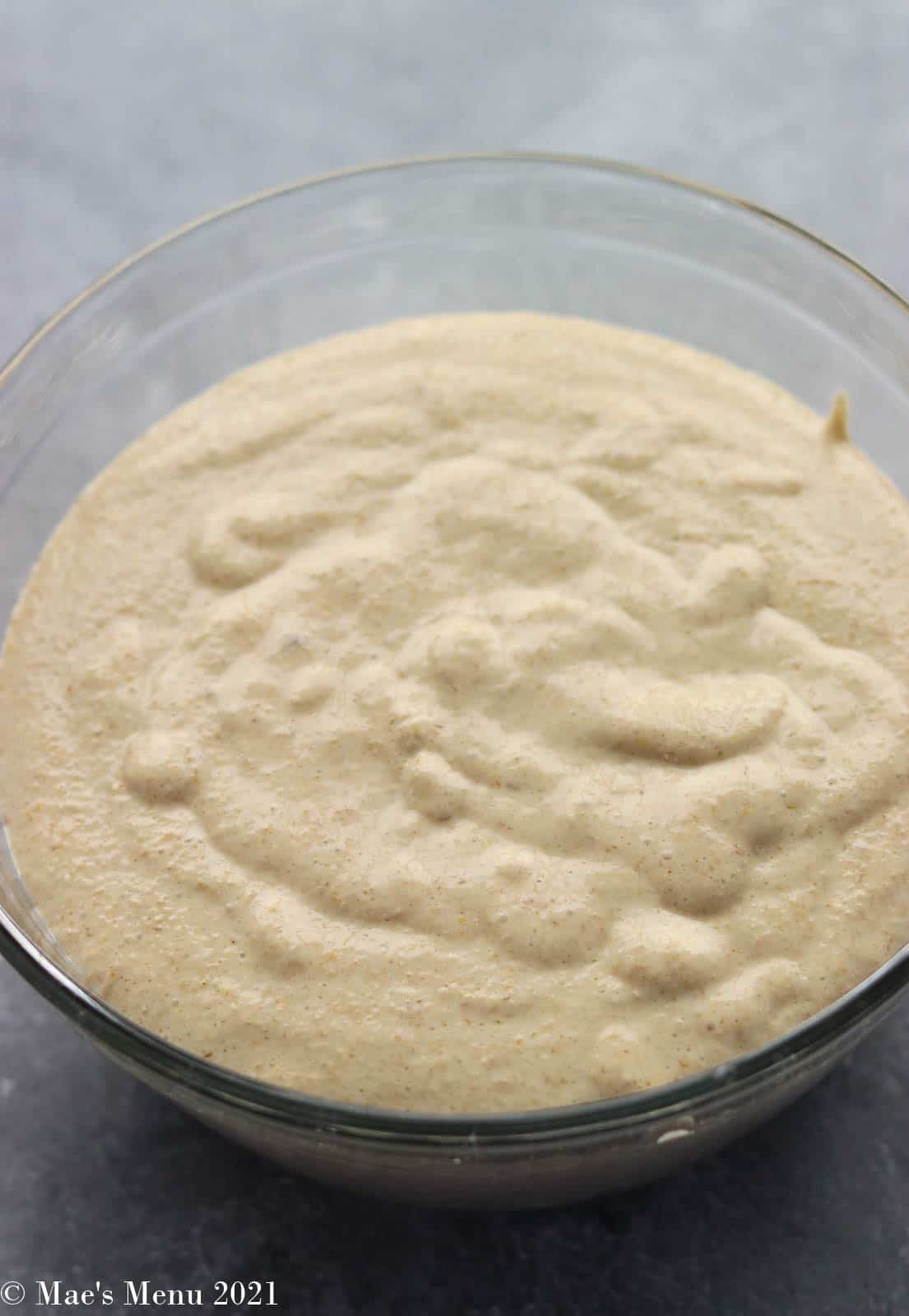 The pancake batter resting in a glass bowl