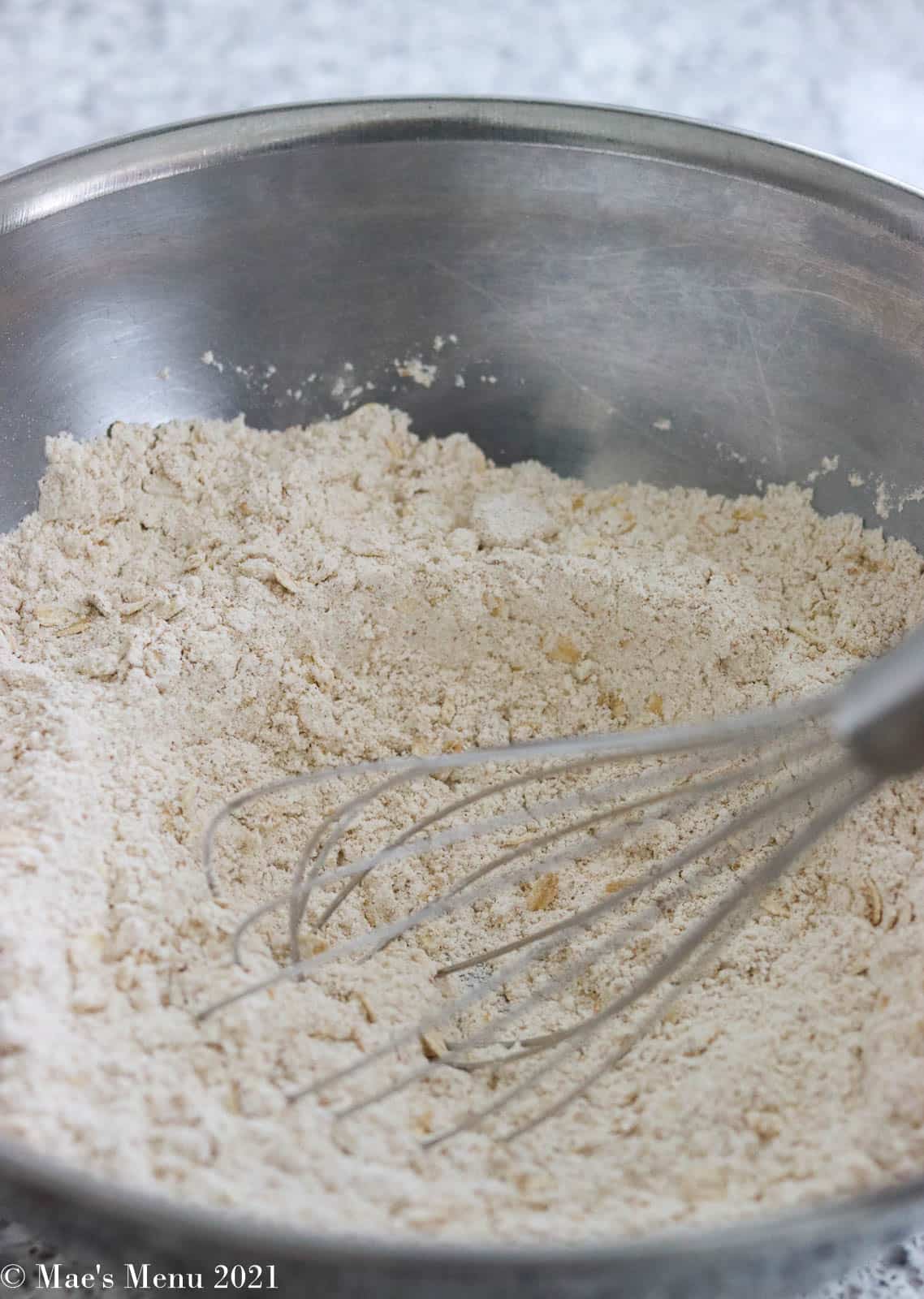 A large mixing bowl full of oatmeal bread's dry ingredients
