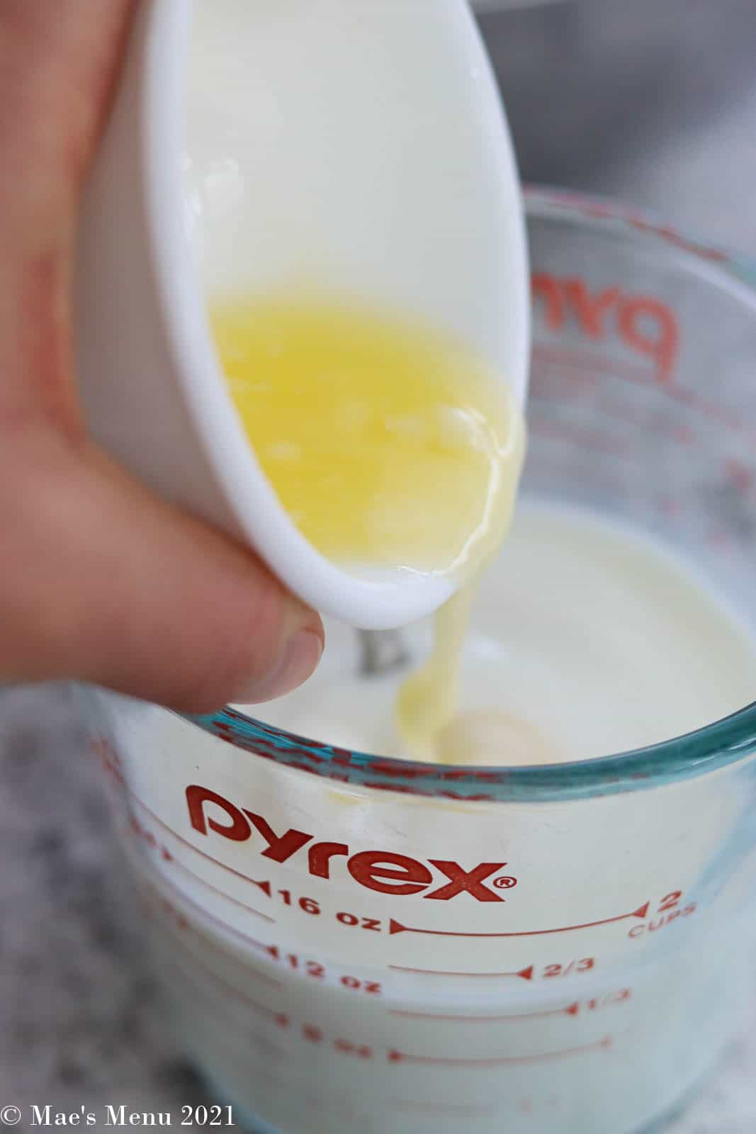 Pouring melted butter into milk