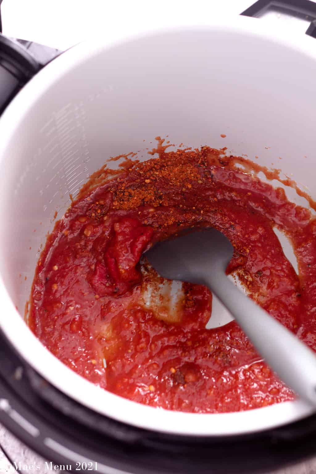 An instant pot with salsa, tomato paste, and seasonings