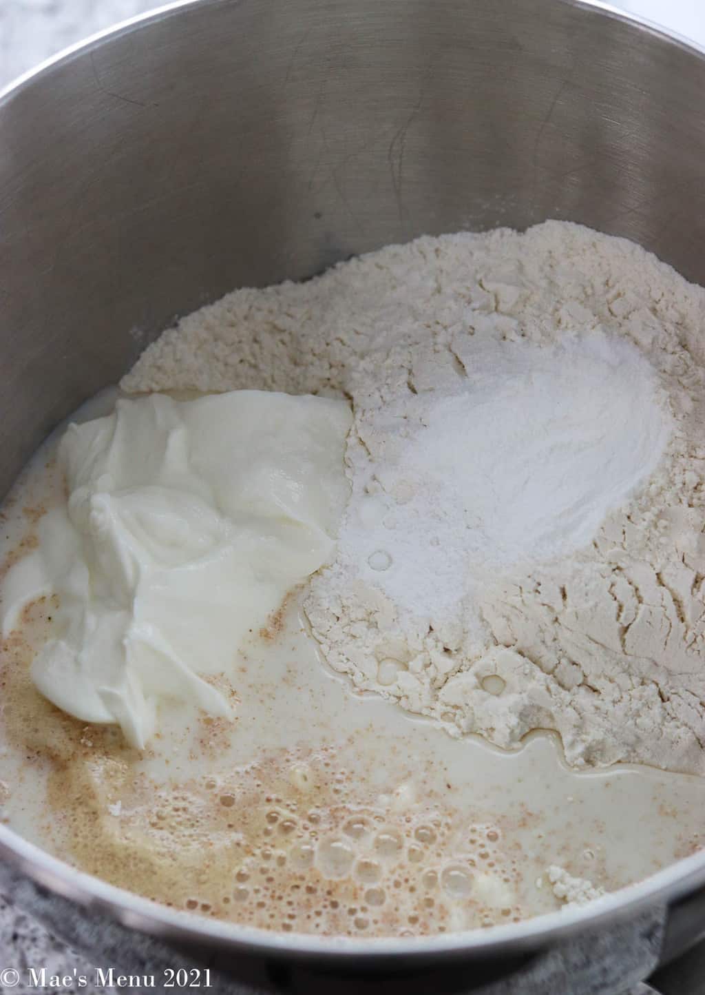 Adding flour, greek yogurt, milk, and other ingredients to the mixing bowl