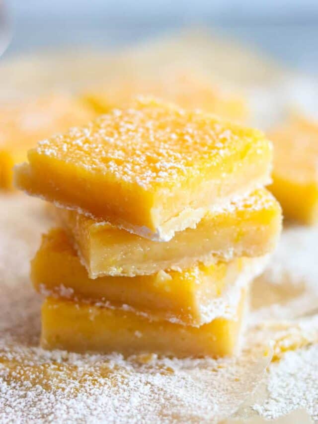 A stack of lemon bars on parchment paper