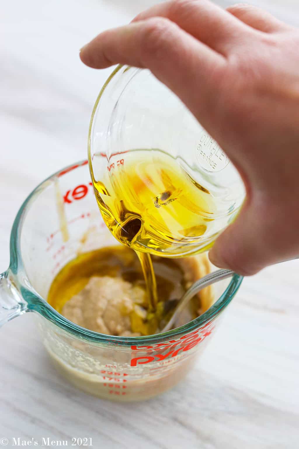 Pouring olive oil into the tahini mixture
