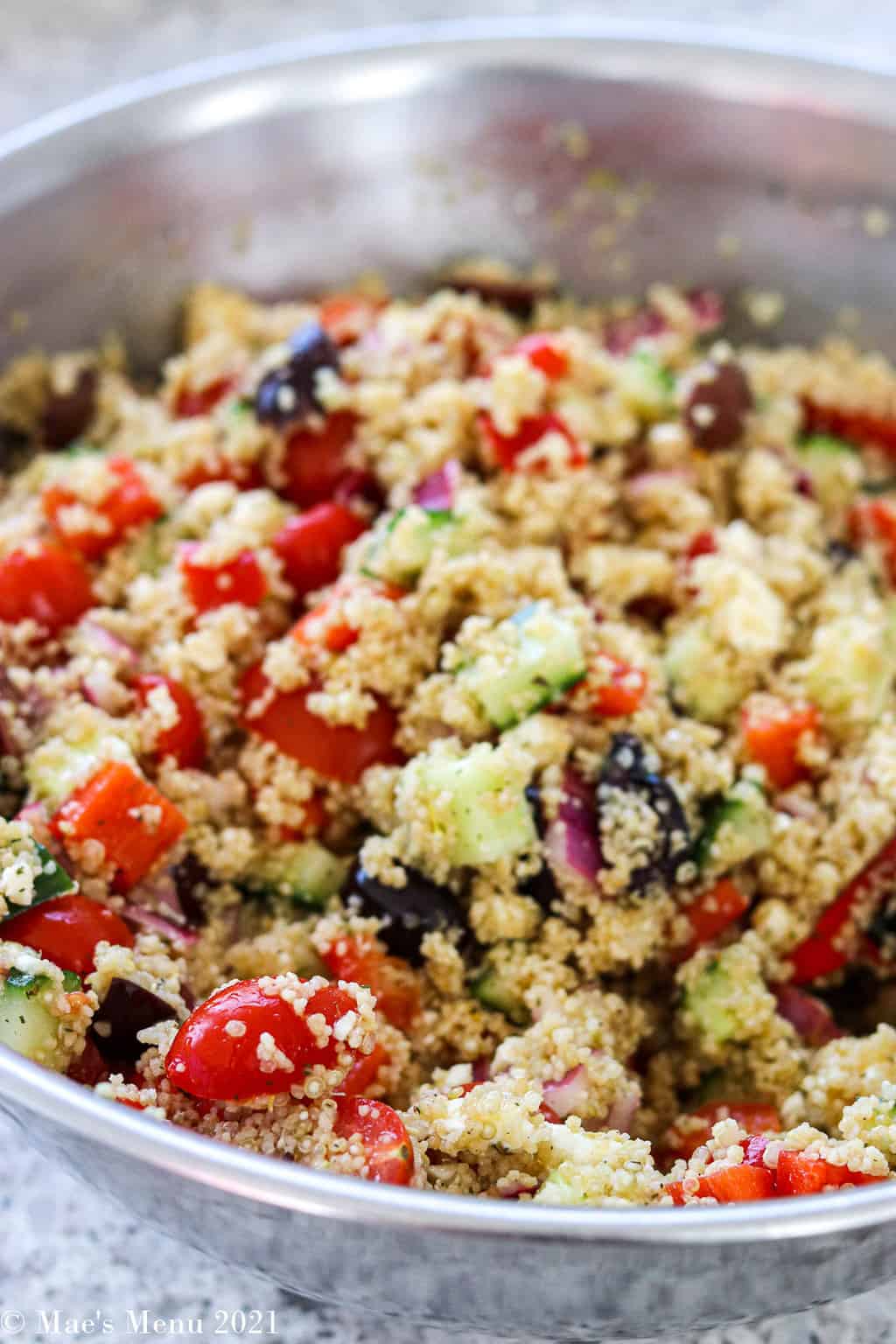 Greek Quinoa salad mixed up in a large mixing bowl