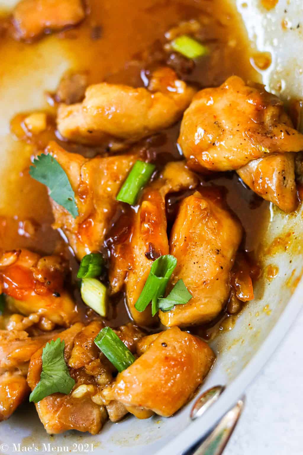 An up-close shot of healthy orange chicken in a saute pan