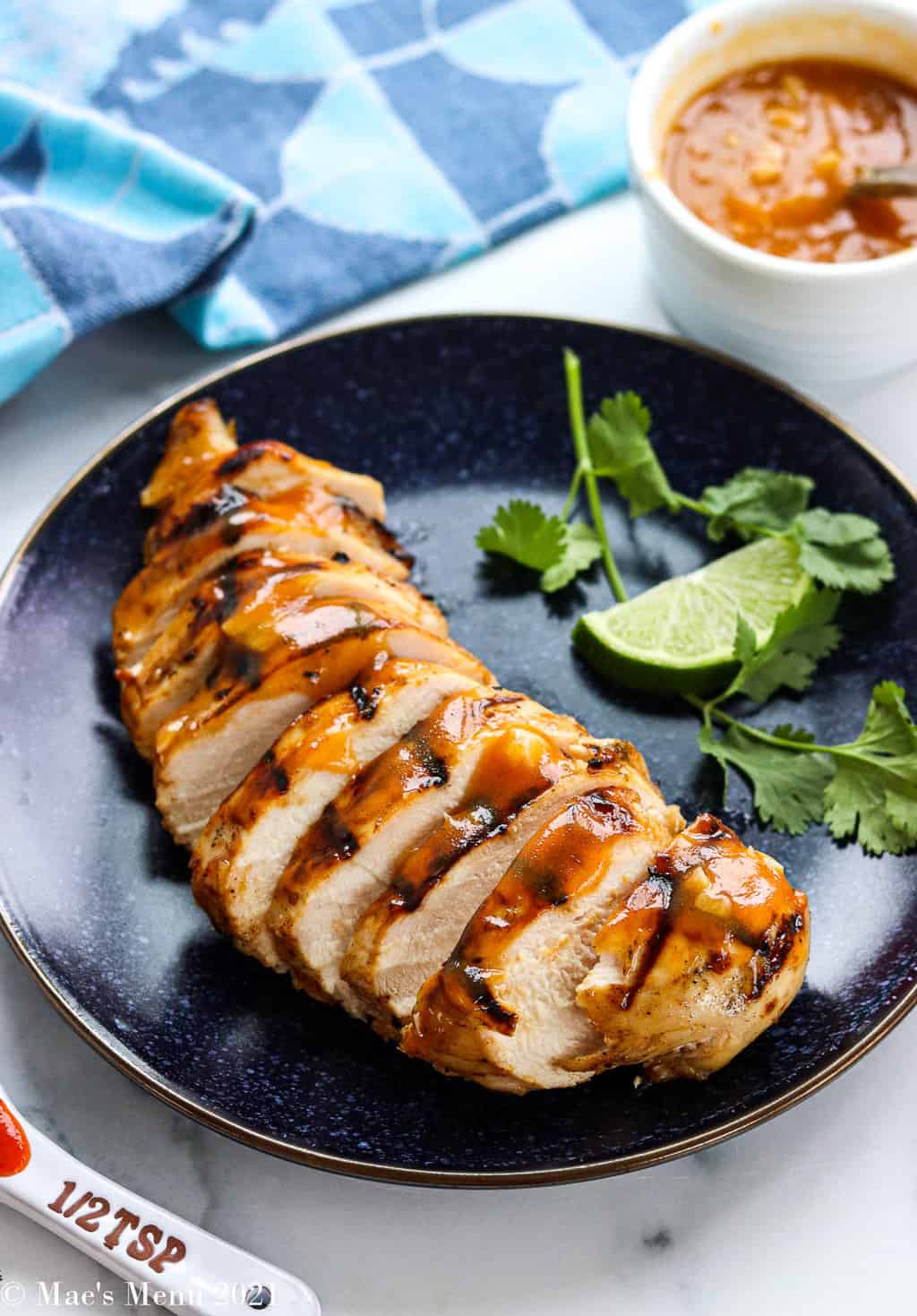 A side shot of a plate of sliced spicy honey grilled chicken 
