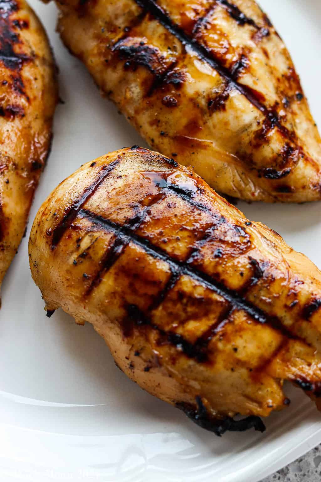 An up-close shot of spicy honey grilled chicken on a white plate 