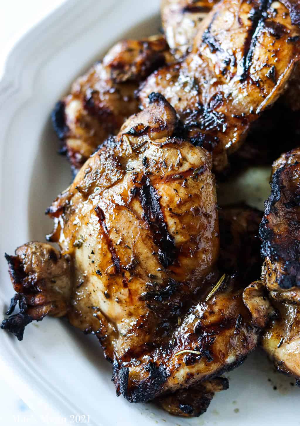 An up-close shot of the best grilled chicken thighs on a white plate