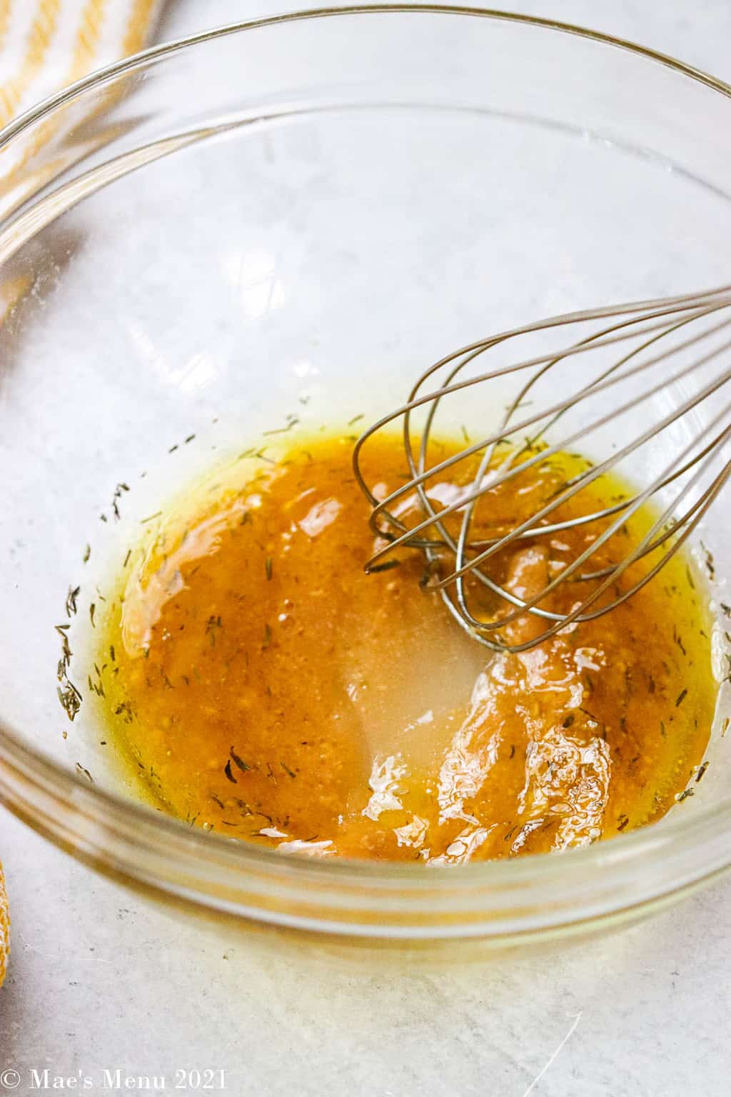 Whisking the salad dressing together in a large glass bowl