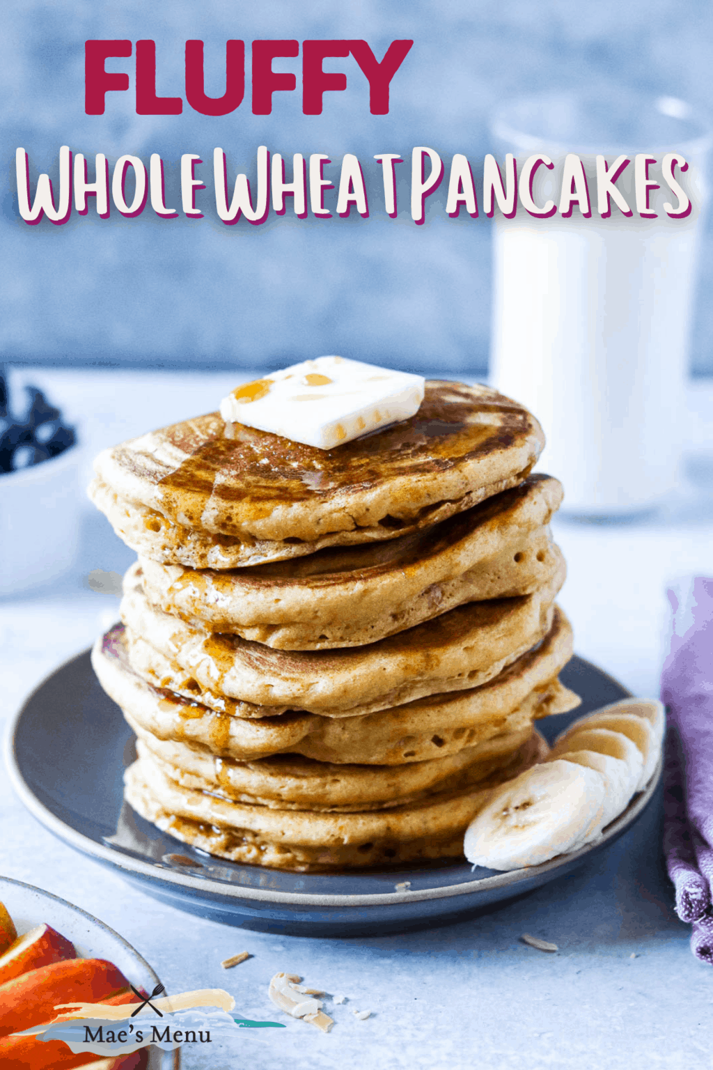 A pinterest pin for fluffy whole wheat pancakes with a stack of pancakes on a plate with butter and bananas 
