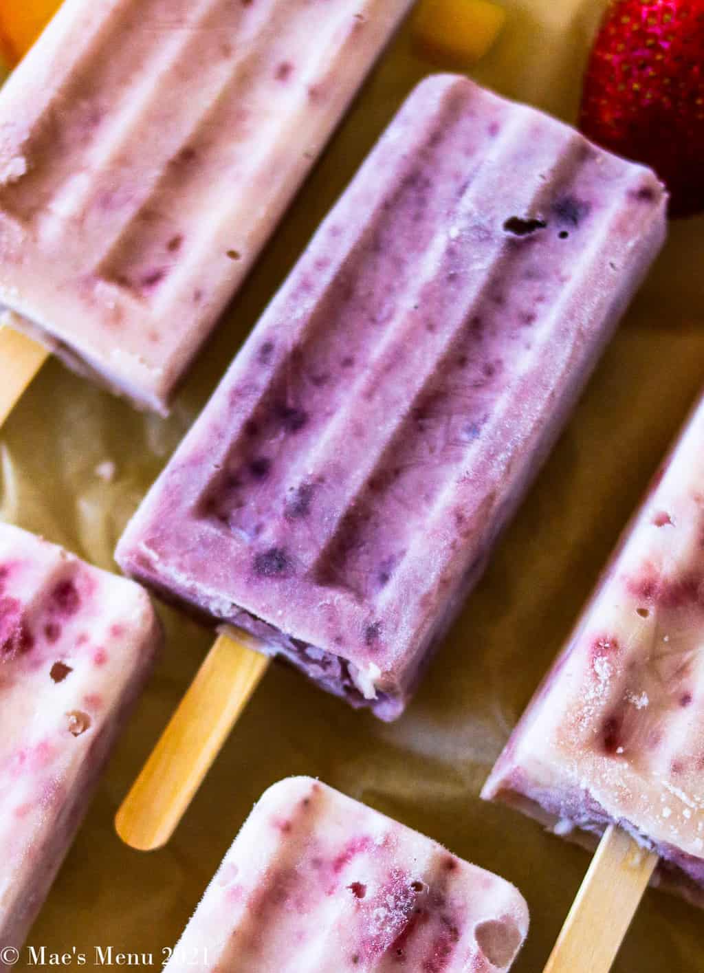 An up close shot of a blueberry popsicle surrounded by other popsicles