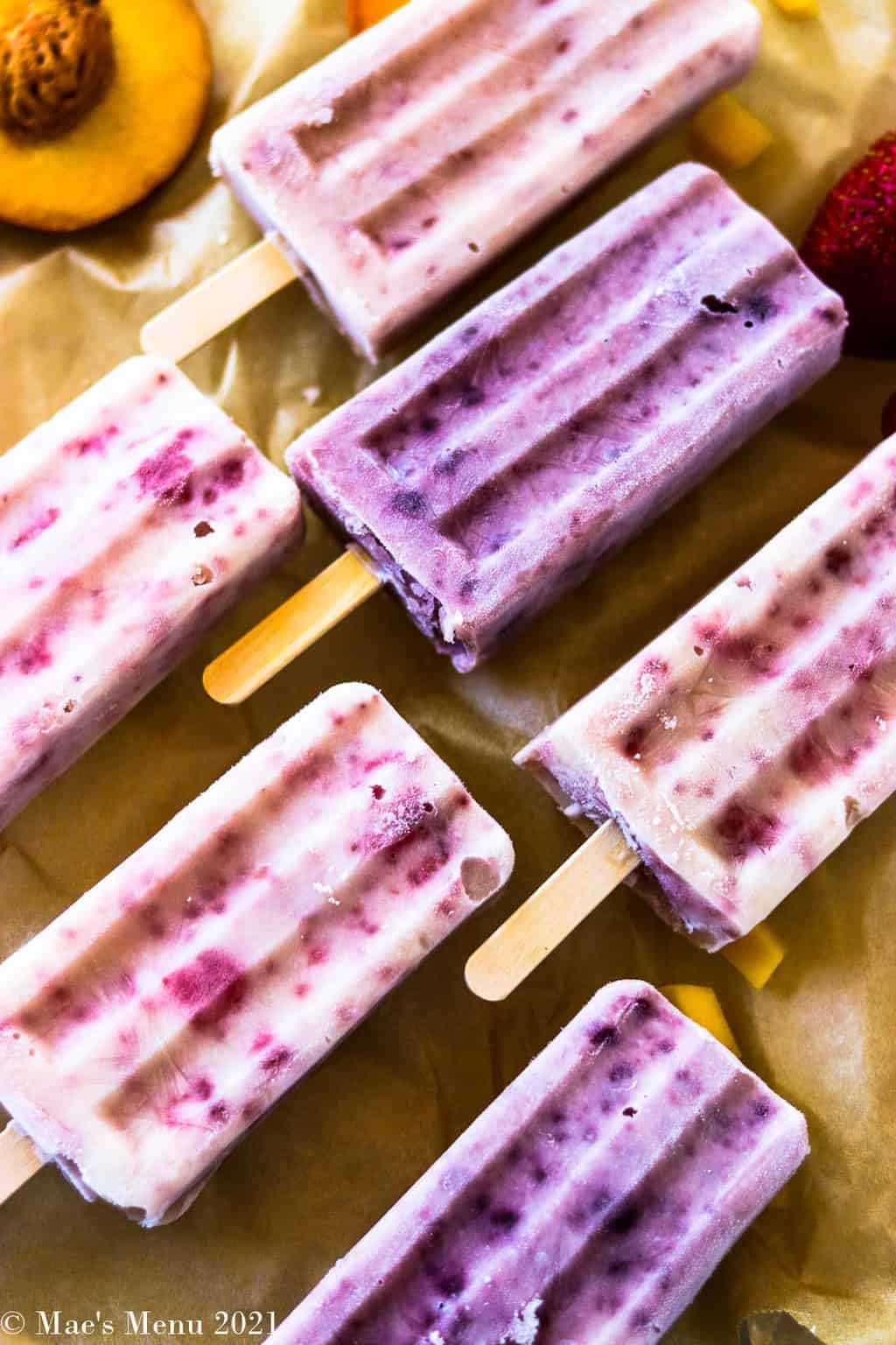 Healthy fruit and yogurt popsicles on a piece of parchment paper