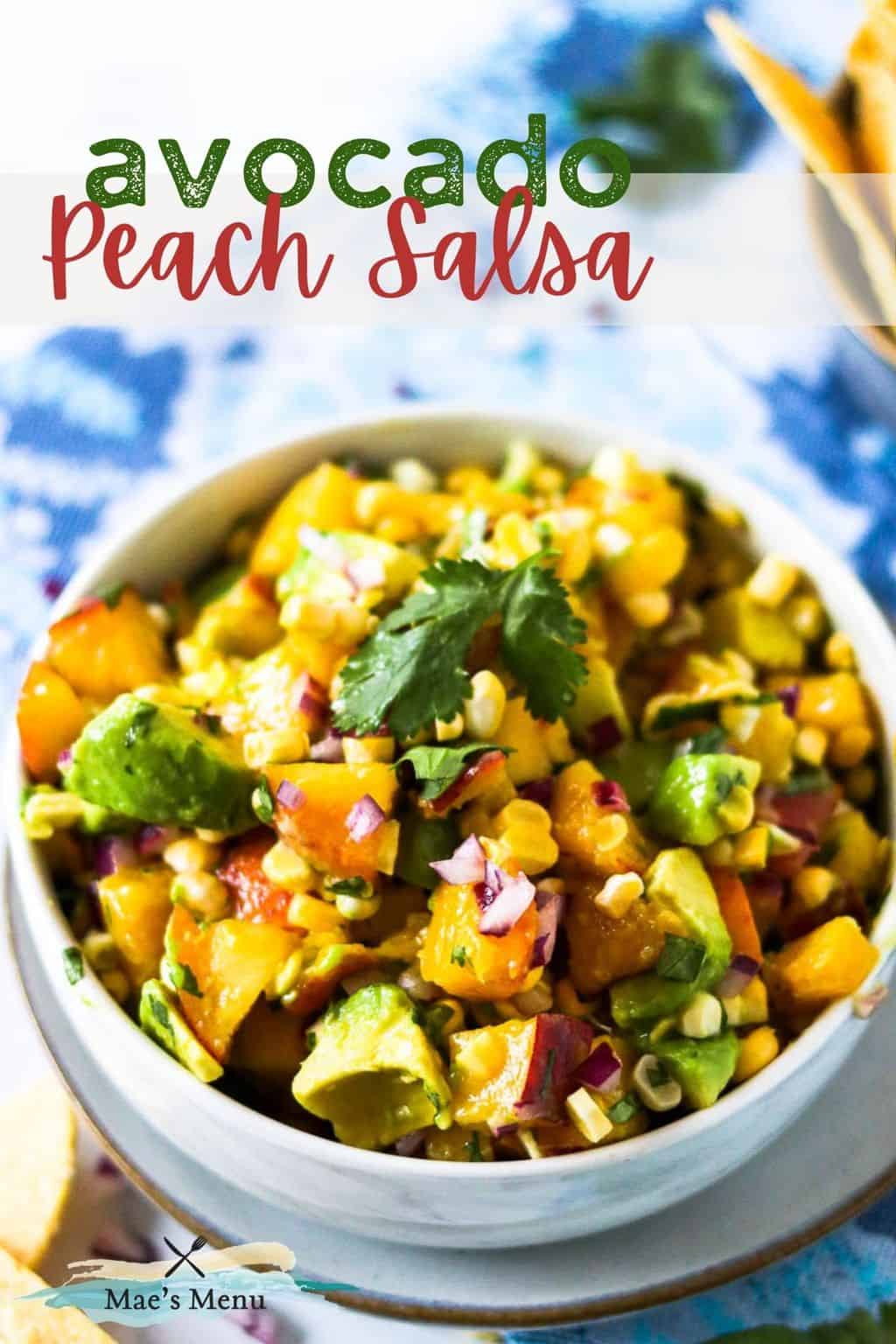 A pinterest pin with an upclose shot of a bowl of avocado peach salad with cilantro on top.