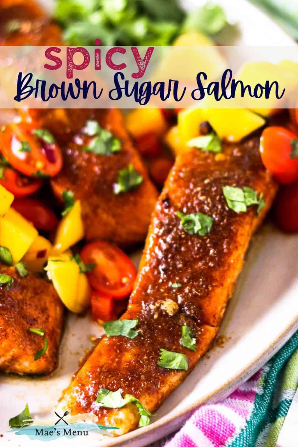 A pinterest pin for spicy brown sugar salmon with an up-close shot of the salmon on a platter with mango salsa