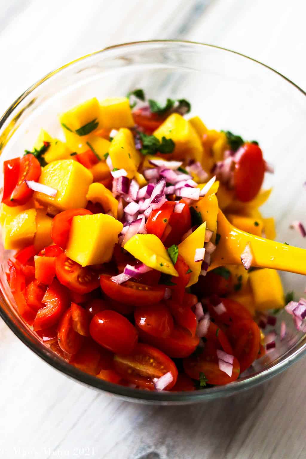 A mixing bowl full of mango salsa