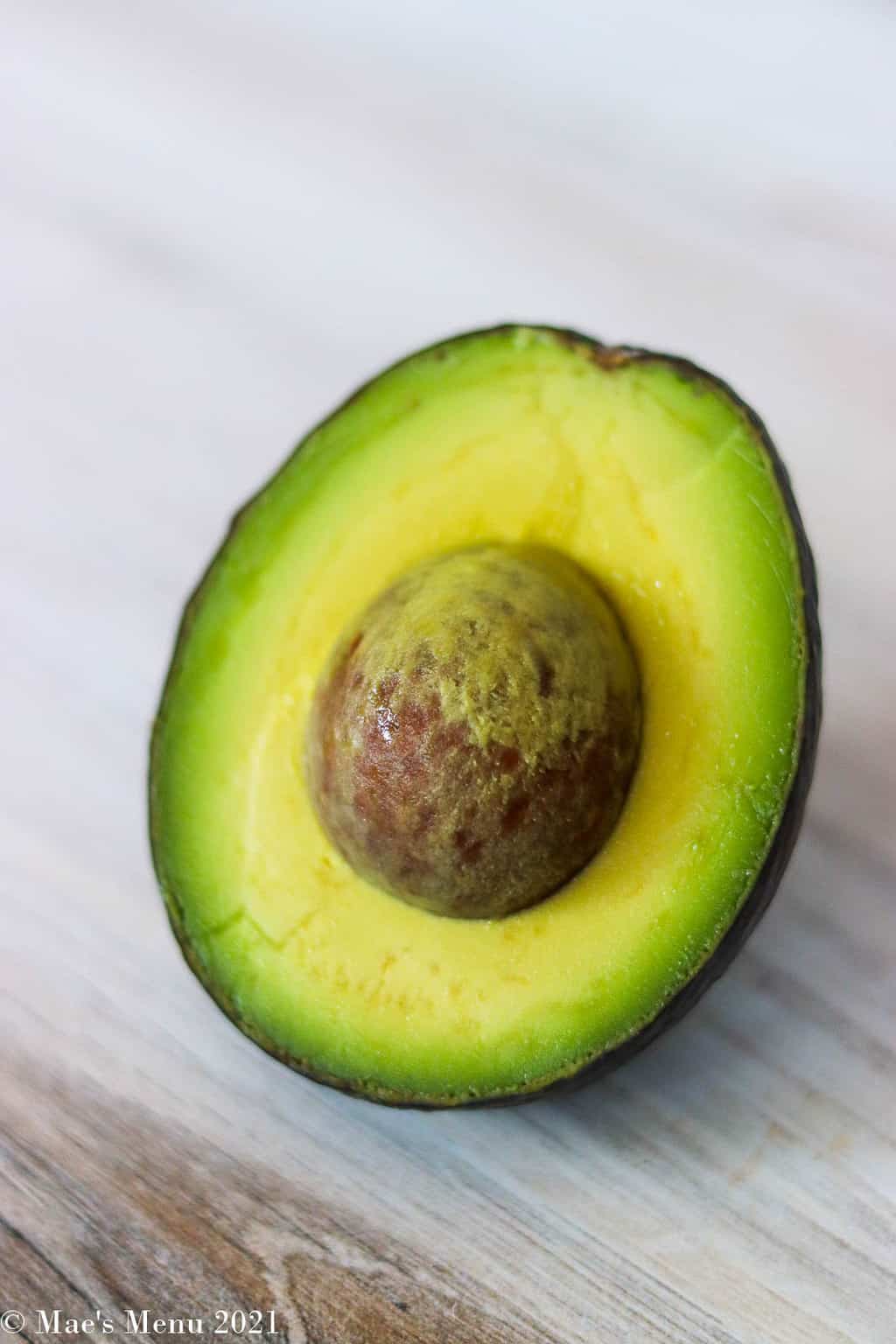 A side shot of a halved avocado