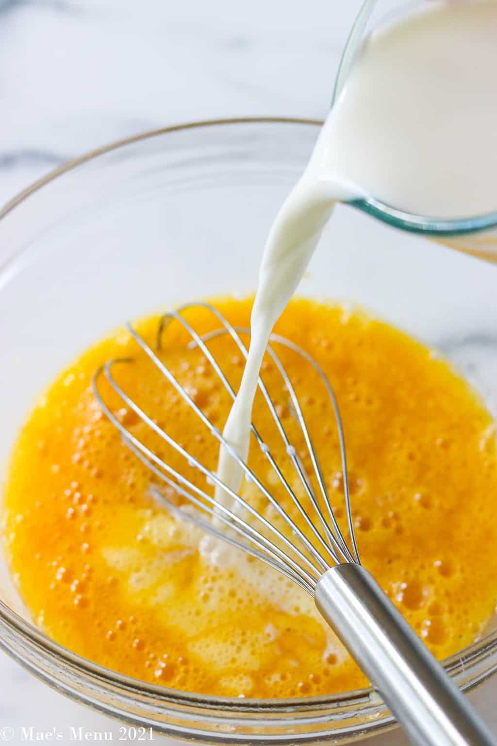 Pouring milk into the whisked eggs