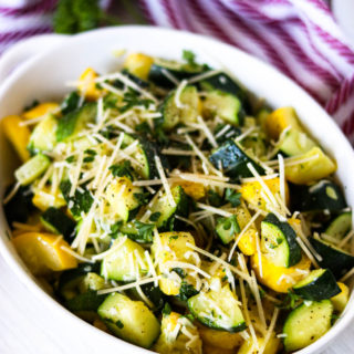 A side angle shot of a bowl of sauteed zucchini and yellow squash