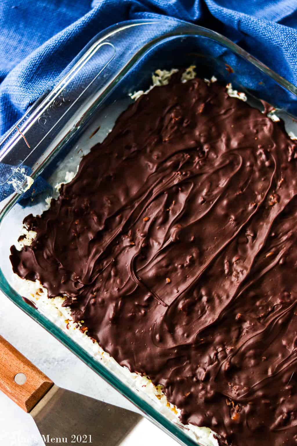 An overhead shot of a cooled pan of chocolate coconut bars