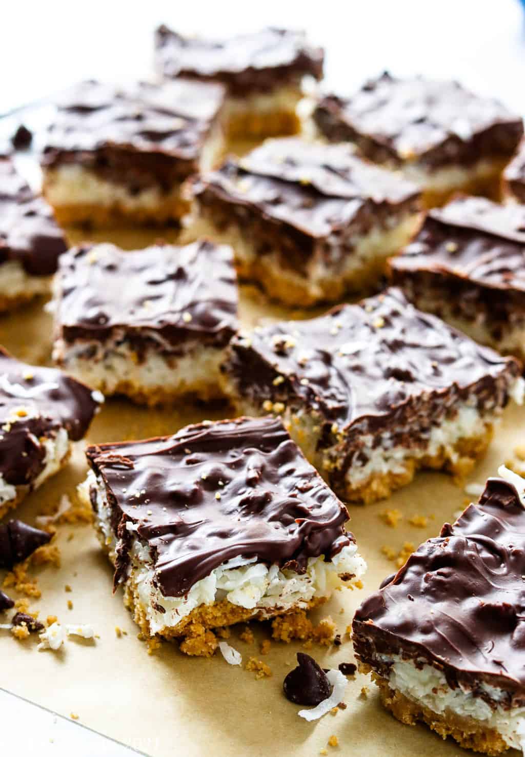 Chocolate coconut bars on a parchment paper with light in the background