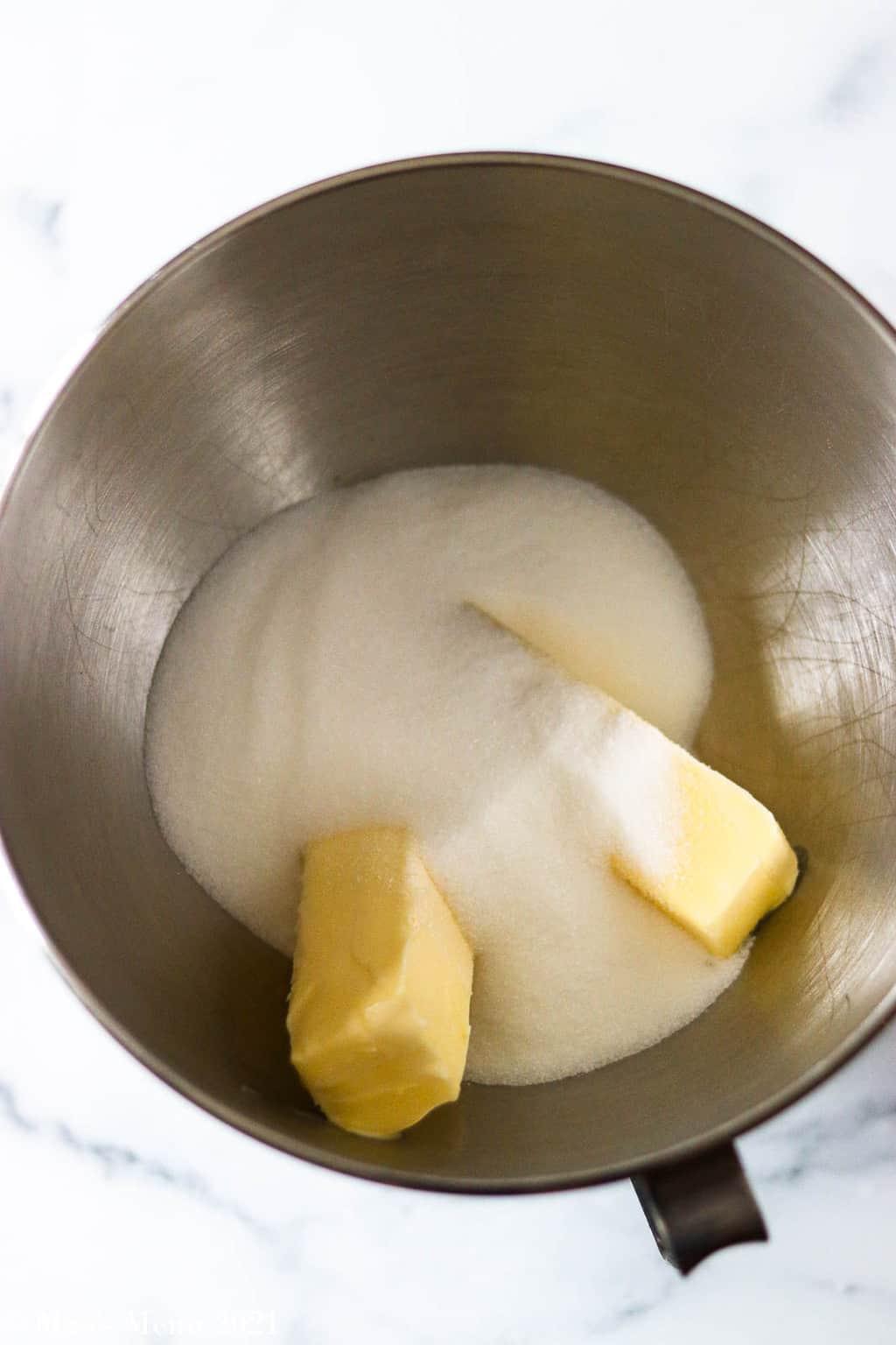 Granulated sugar and butter in a mixing bowl