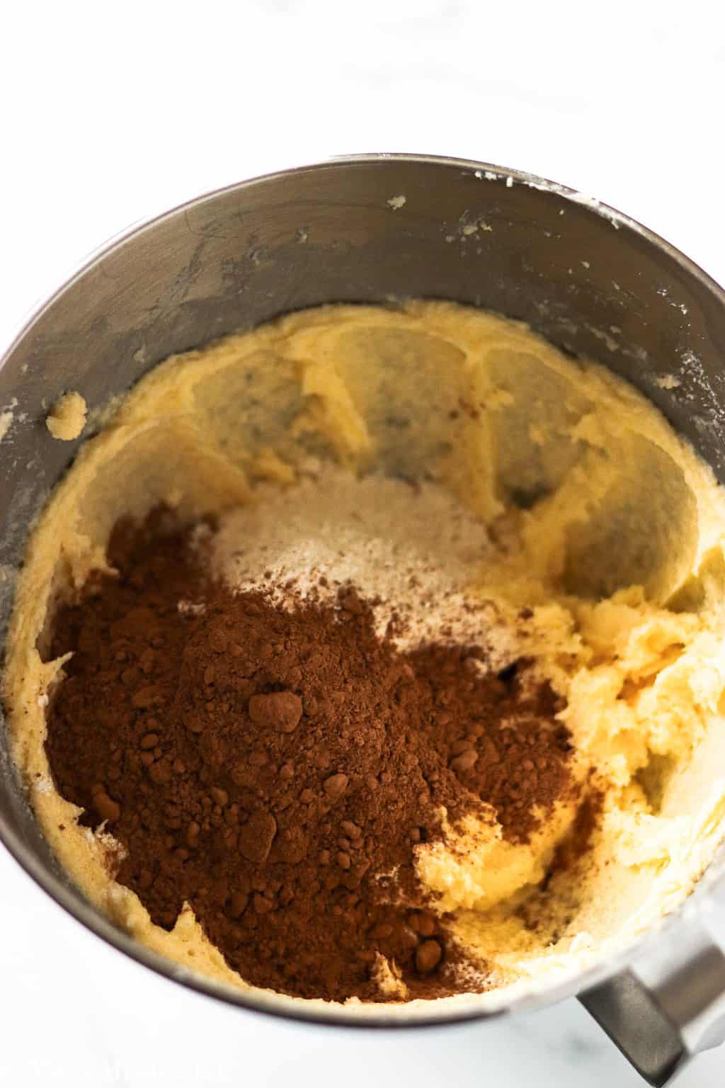 A mixing bowl full of creamed butter and cocoa flour mixture