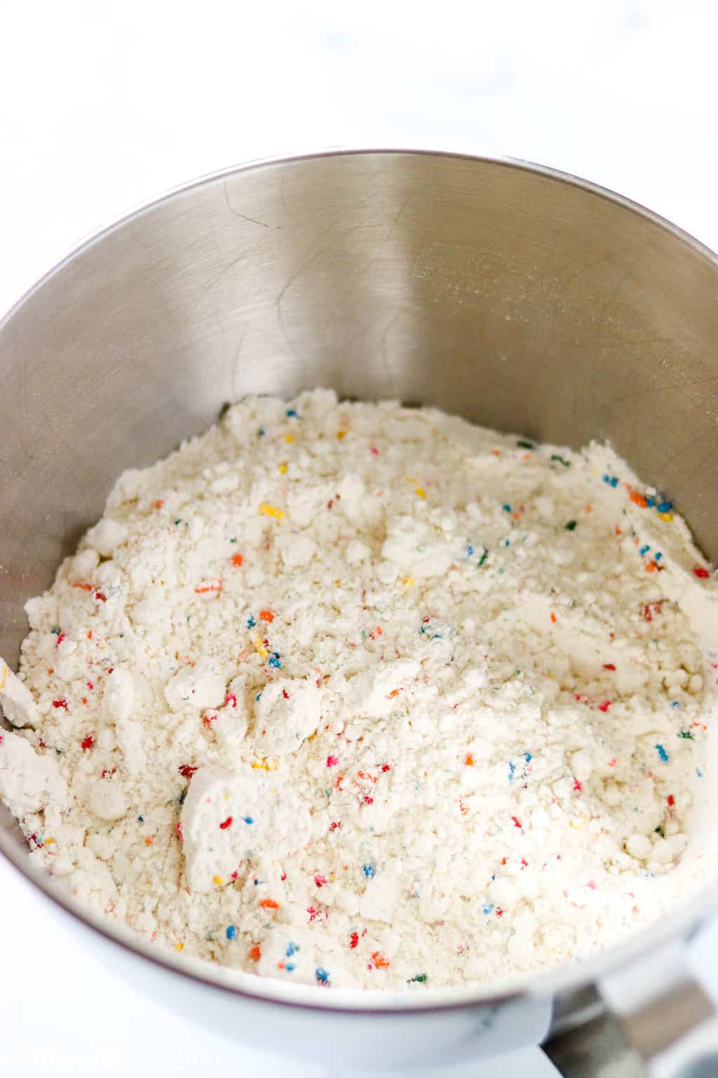 Confetti cake mix, flour, and sugar whisked together in a mixing bowl