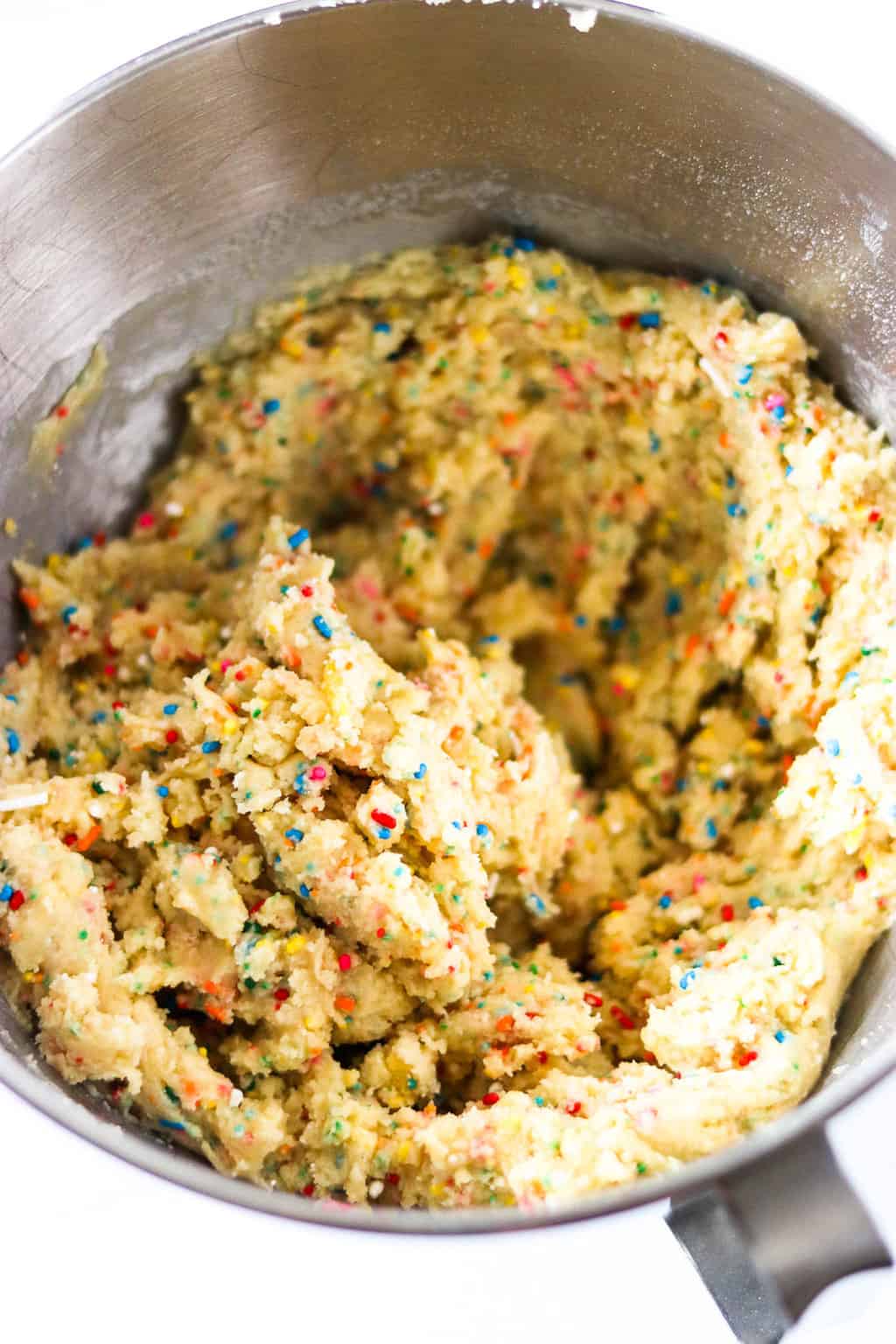 A mixing bowl of confetti cake mix cookie batter
