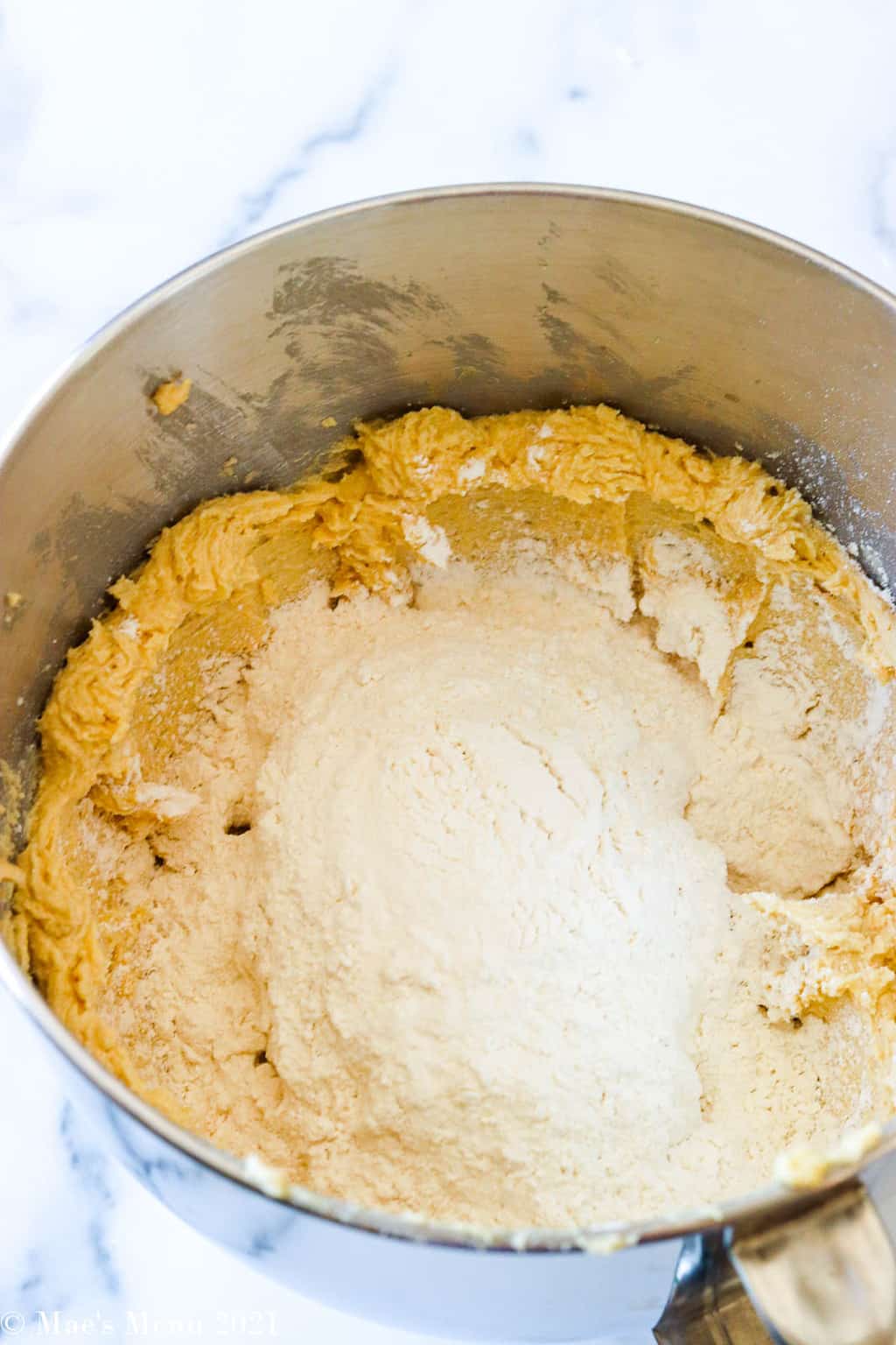 A side shot of a mixing bowl of creamed butter and flour