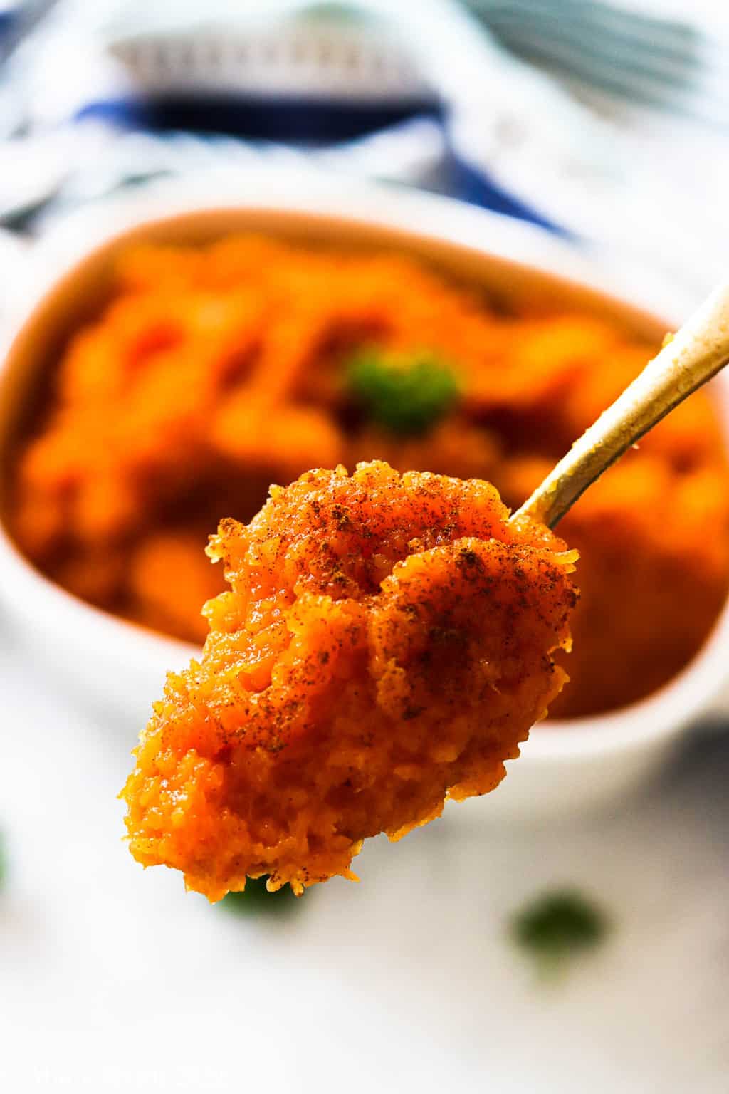 An up-close shot of a serving spoon of mashed butternut squash