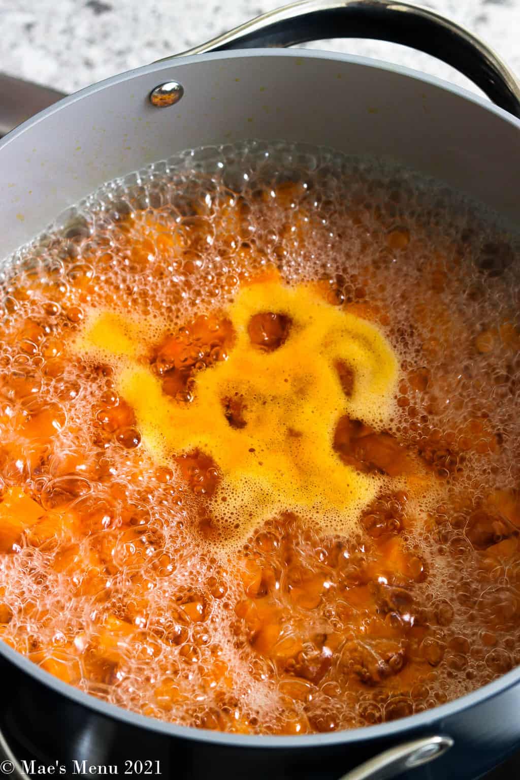 A side shot of a pot of boiling water with butternut squash