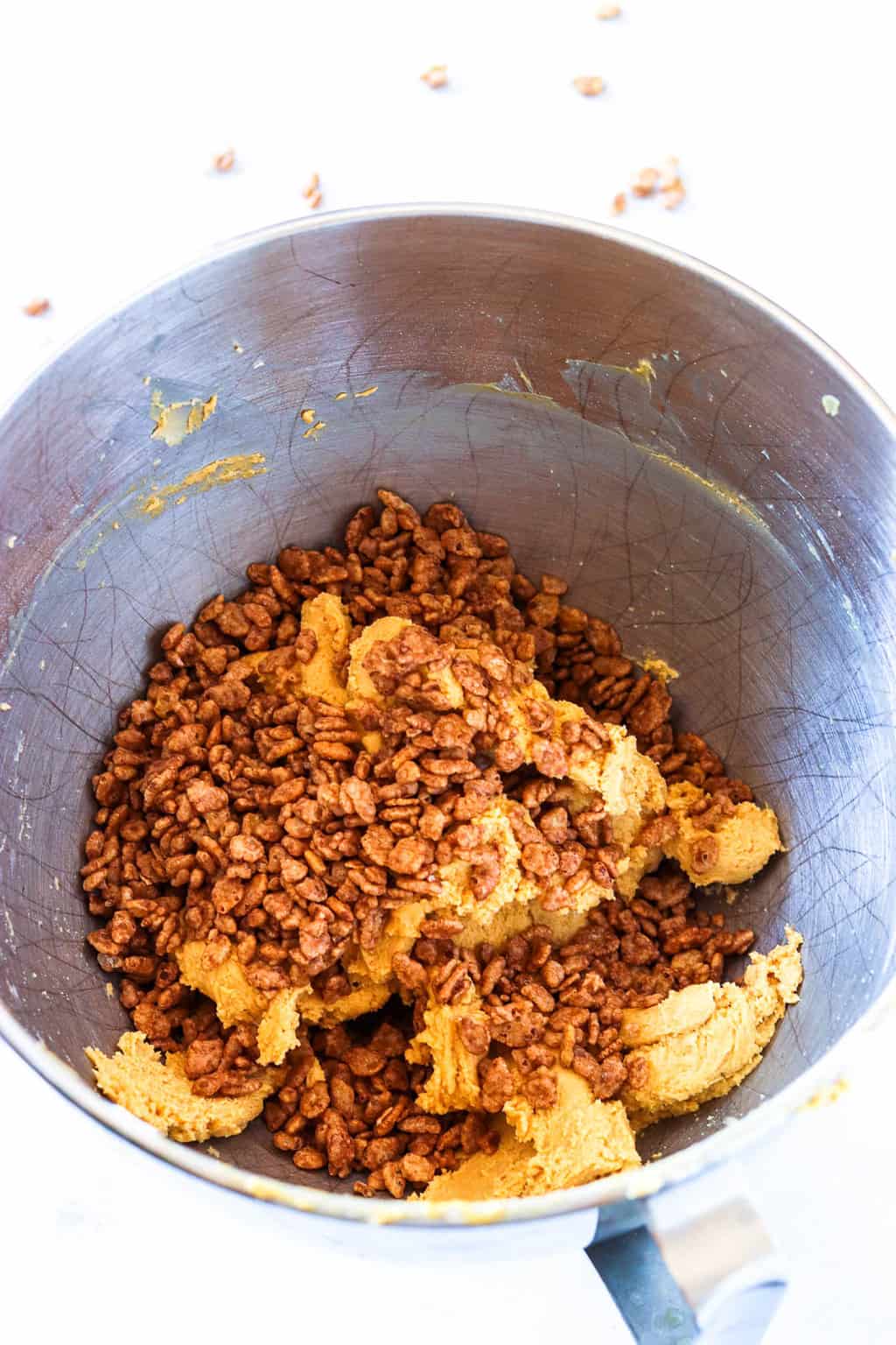 An overhead shot of a mixing bowl of peanut butter dough with cocoa krispies