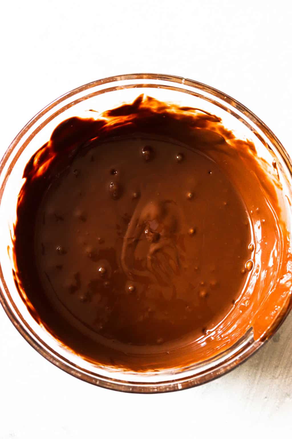 An overhead shot of a small mixing bowl with melted chocolate in it