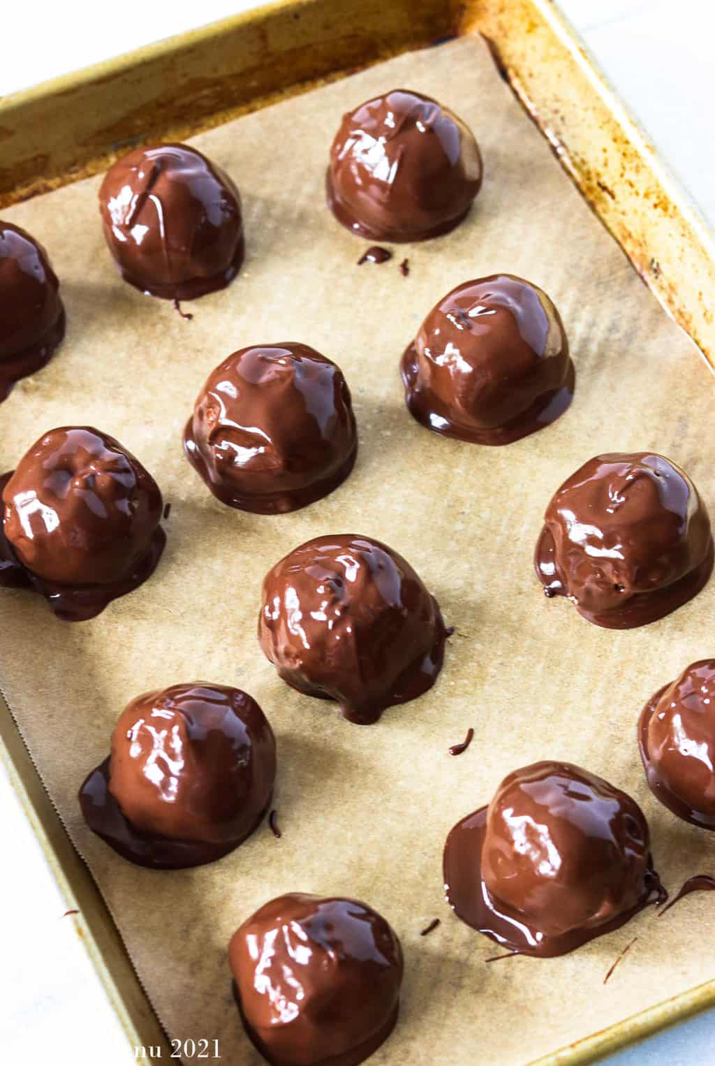 A sie angled shot of peanut butter bon bons glazed in chocolate