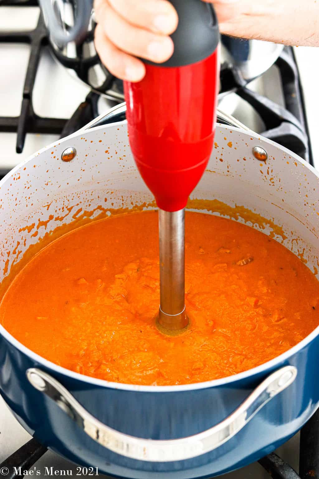 Pureeing the pumpkin pasta sauce in a Dutch oven