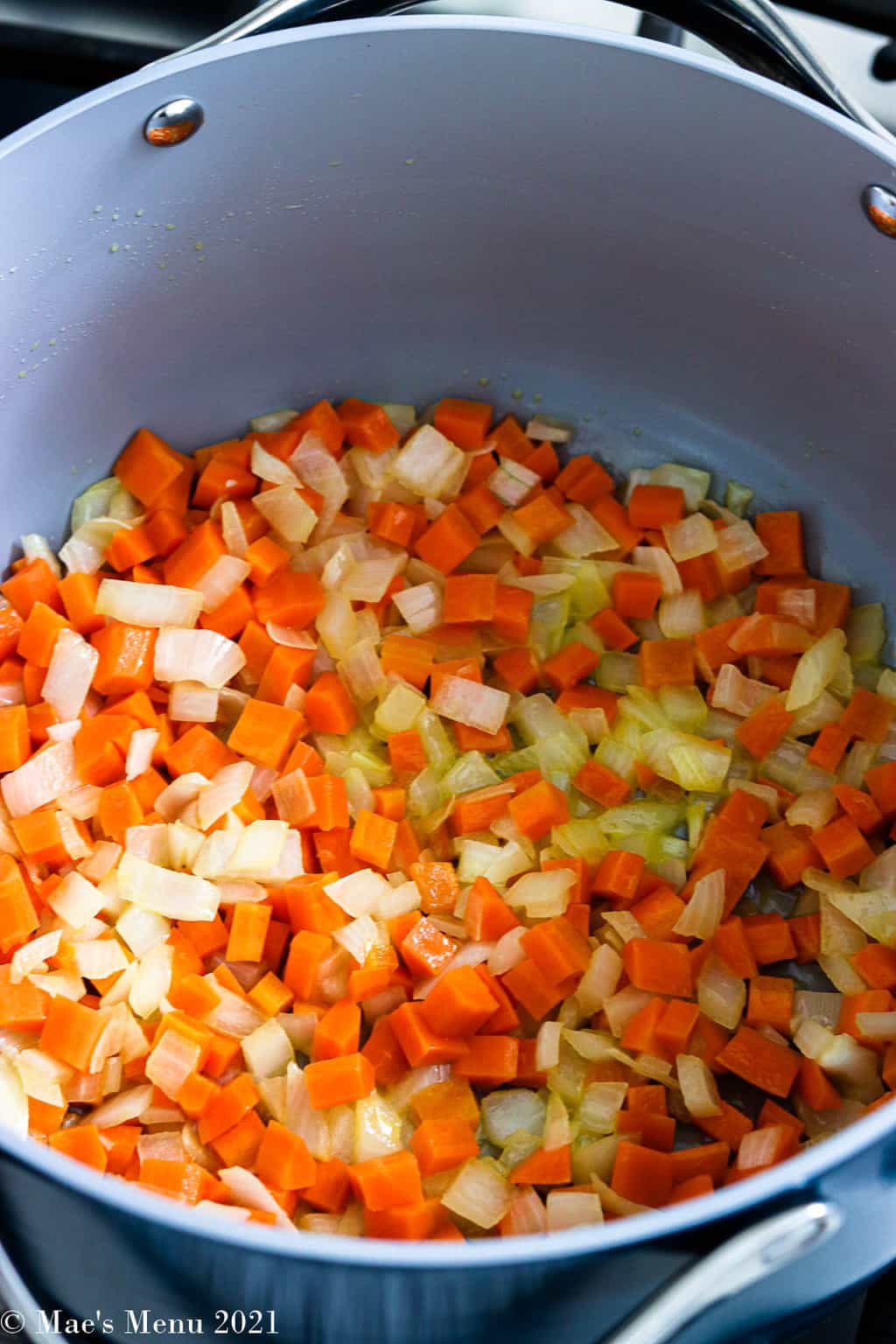 A stockpot of sauteed onion and carrots