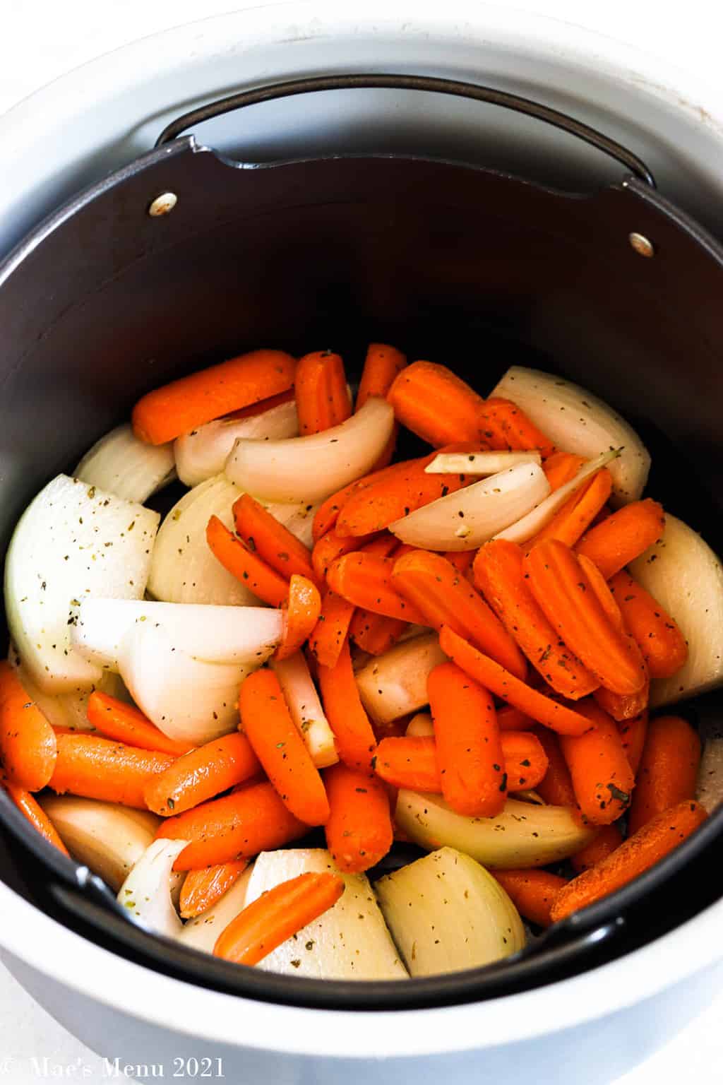 Carrots and onions in an air fryer basket