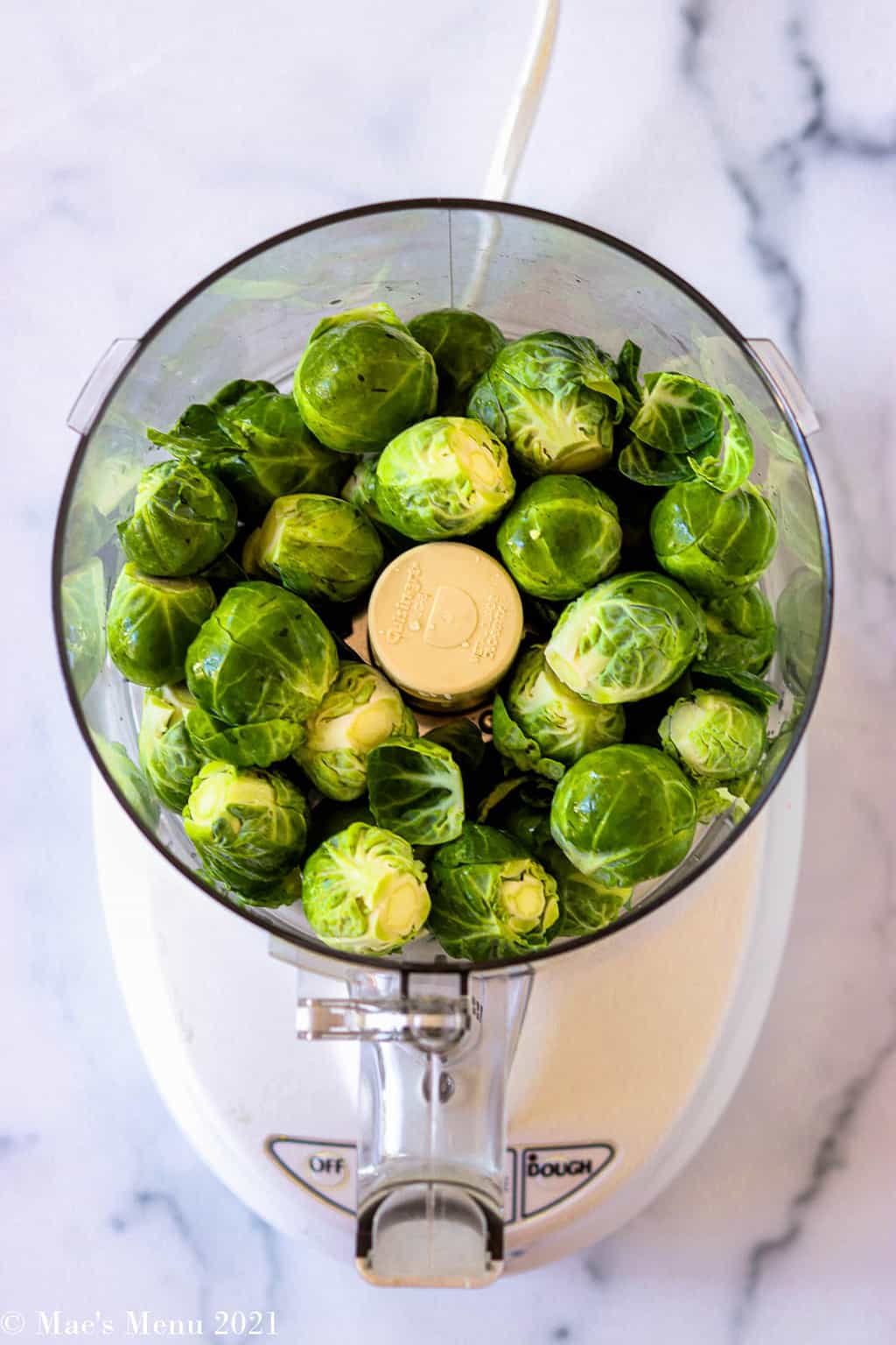 An overhead shot of a food processor with brussels sprouts