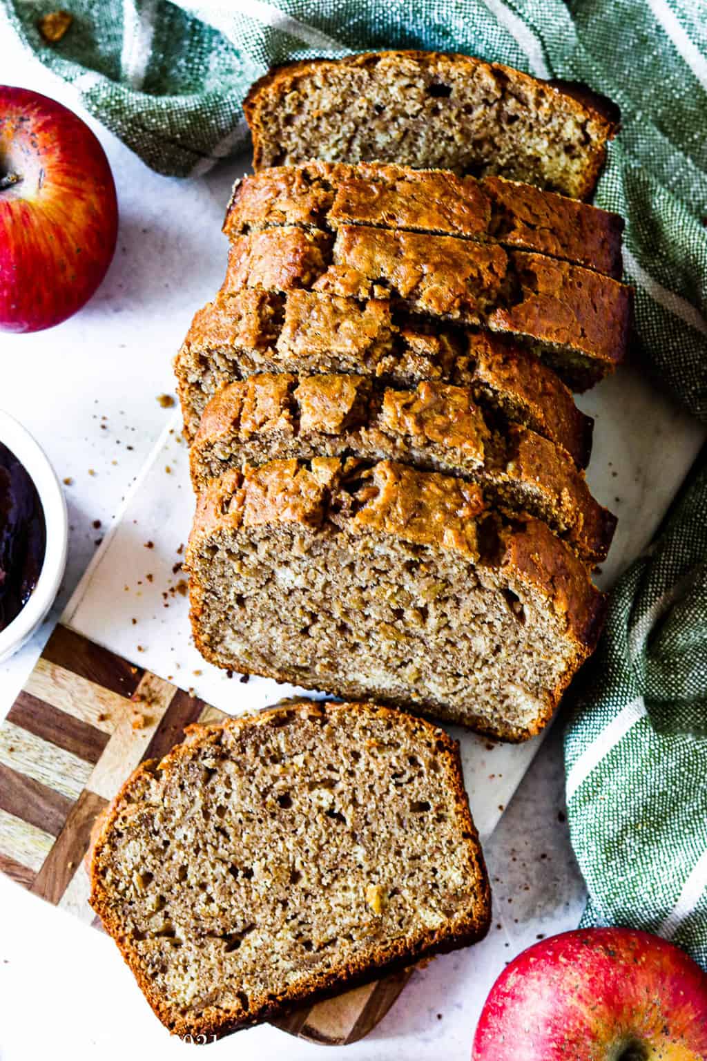 Healthy cinnamon apple bread sliced up and resting on a cutting board