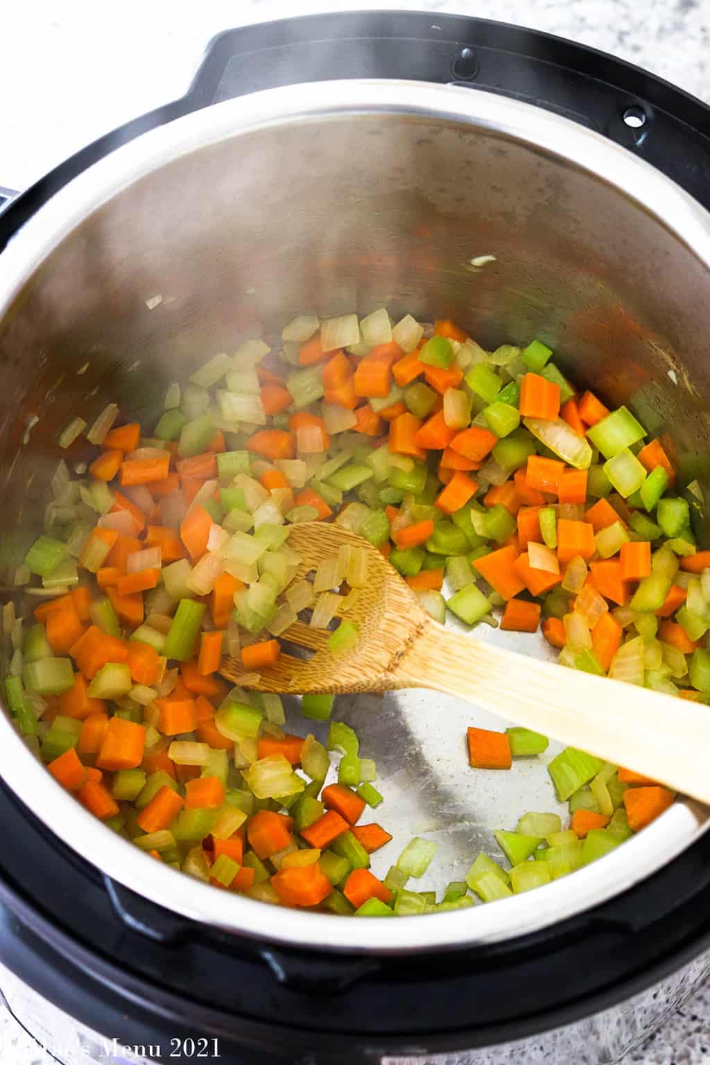 An overhead shot of an instant pot sauteing onions, celery, and carrots
